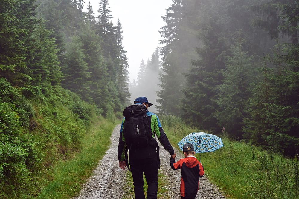 Chlapec s otcem jdou v mlžných lesích Jeseniků